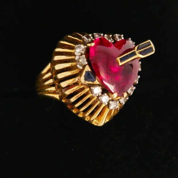 18k Heart shape ruby ring with a sapphire tip arrow piercing the center illusion, accented with diamonds